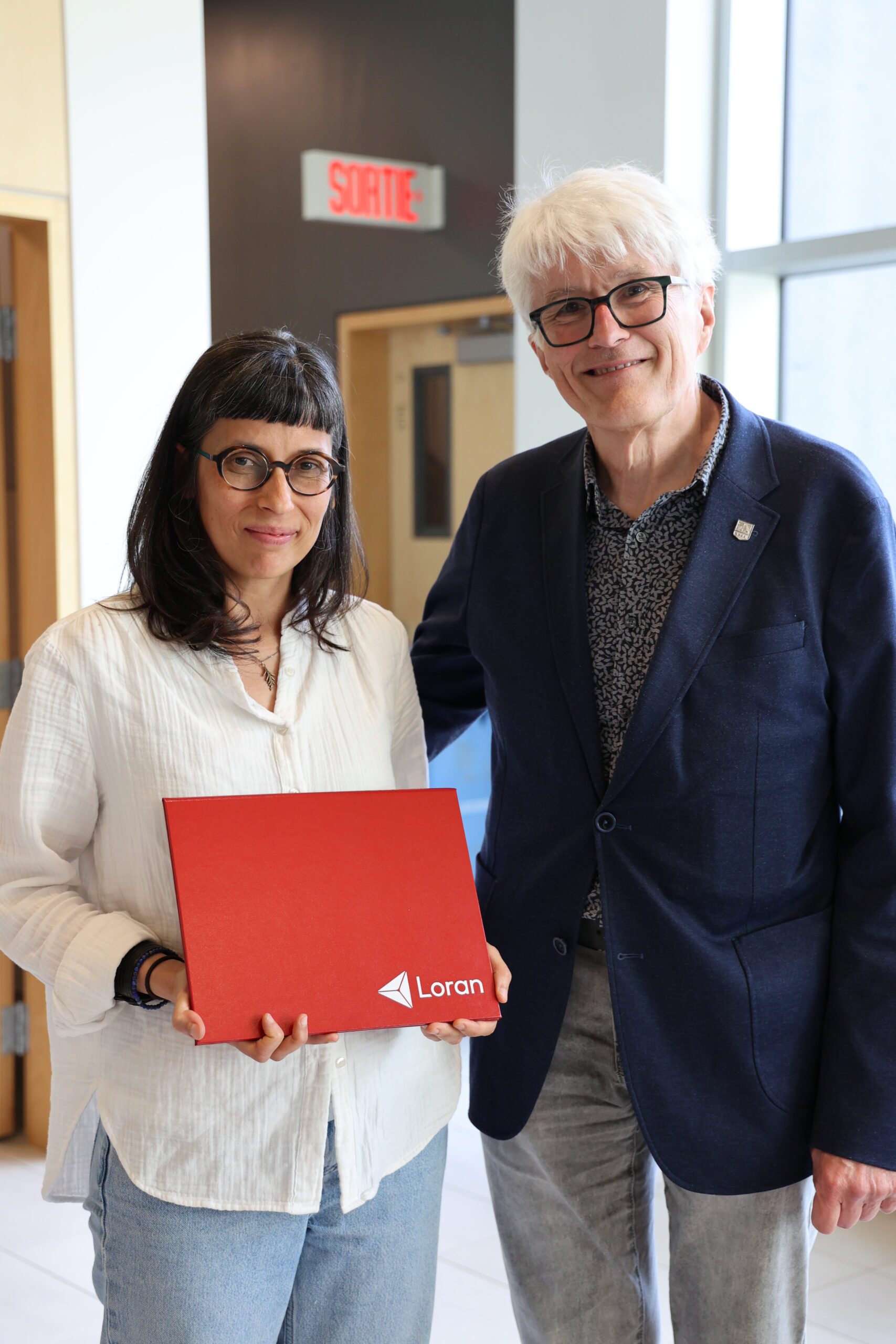 Suzanne Lemay receives the award from Director of the Constituent College Edward Berryman.